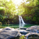 Tropical waterfall Lower Waikamoi Falls and a small crystal clear pond, inside of a dense tropical rainforest, off the Road to Hana Highway, Maui, Hawaii, USA